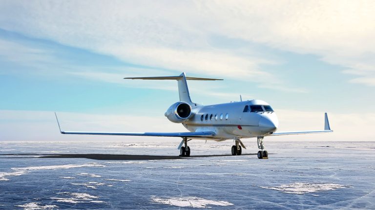 Plane on a grey runway against a clear blue sky.